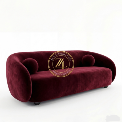 Modern curved Burgundy velvet sofa with round cushions by Zauq Living Lahore.