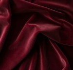 Modern curved Burgundy velvet sofa with round cushions in a luxury Lahore living room - Zauq Living.